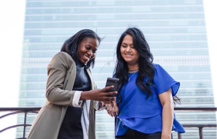 Two teammates viewing a mobile phone