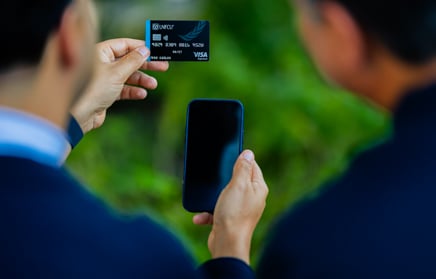 Two individuals looking at mobile device and credit card